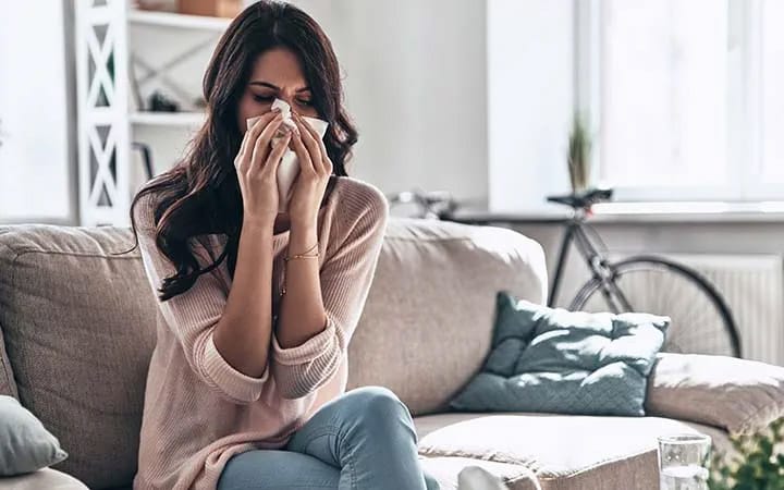 Top Signs Your Raleigh Home Needs Professional Duct Cleaning 3 Family member sneezing due to allergens from dirty air ducts in Raleigh home