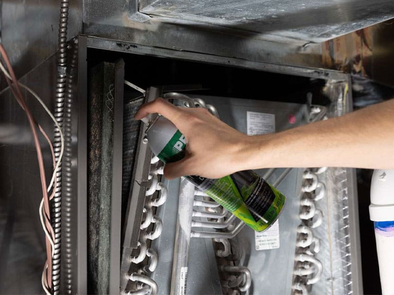 Mold in Your Air Ducts? What Raleigh Homeowners Need to Know 3 DuctNClean technician cleaning condenser coil to prevent mold in Raleigh HVAC system