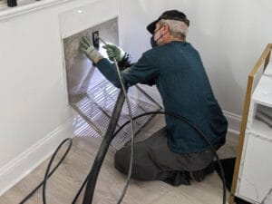 Technician cleaning a return during an air duct cleaning in a Raleigh home