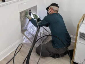 Technician cleaning a return during an air duct cleaning in a Raleigh home